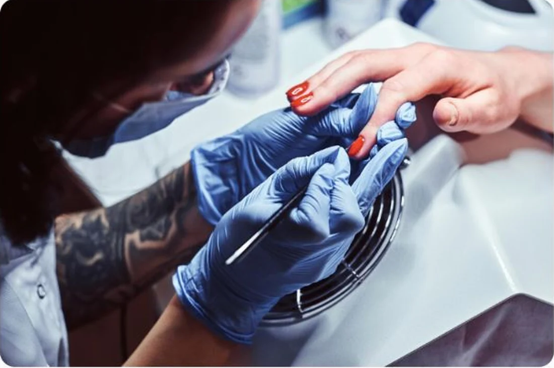 Kosmetyczka wykonująca manicure przy profesjonalnym stanowisku w salonie